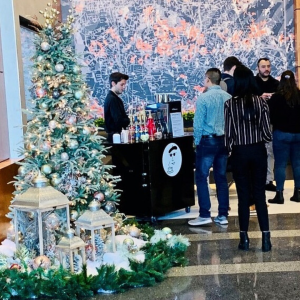 Espresso Dave's Barista serving espressos to crowd in office building at Christmas.