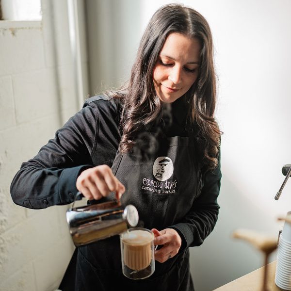 Best Time to drink coffee is when one of Espresso DAves Coffee Catering baristas in a black uniform and black apron makes you a cappuccino in a glass mug. Capture the North Photography