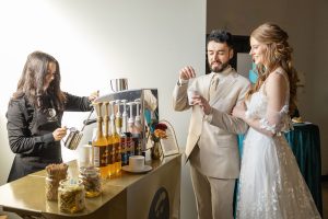 Bride with groom sipping latte at wedding reception in front of Espresso Dave Coffee Catering mobile cart with barista steaming milk Dee Renee photography